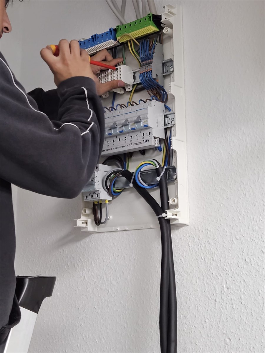 Elektriker beim fachgerechten Anschluss einer Unterverteilung in einem Gebäude